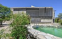 012-casa-cosmos-rammed-stone-and-exposed-concrete-on-a-sloped-site-edge.jpg