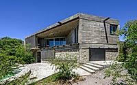 013-casa-cosmos-rammed-stone-and-exposed-concrete-on-a-sloped-site-edge.jpg