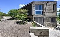 014-casa-cosmos-rammed-stone-and-exposed-concrete-on-a-sloped-site-edge.jpg