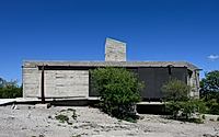 015-casa-cosmos-rammed-stone-and-exposed-concrete-on-a-sloped-site-edge.jpg