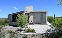 016-casa-cosmos-rammed-stone-and-exposed-concrete-on-a-sloped-site-edge.jpg
